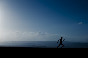 Silhouette of person running at dusk