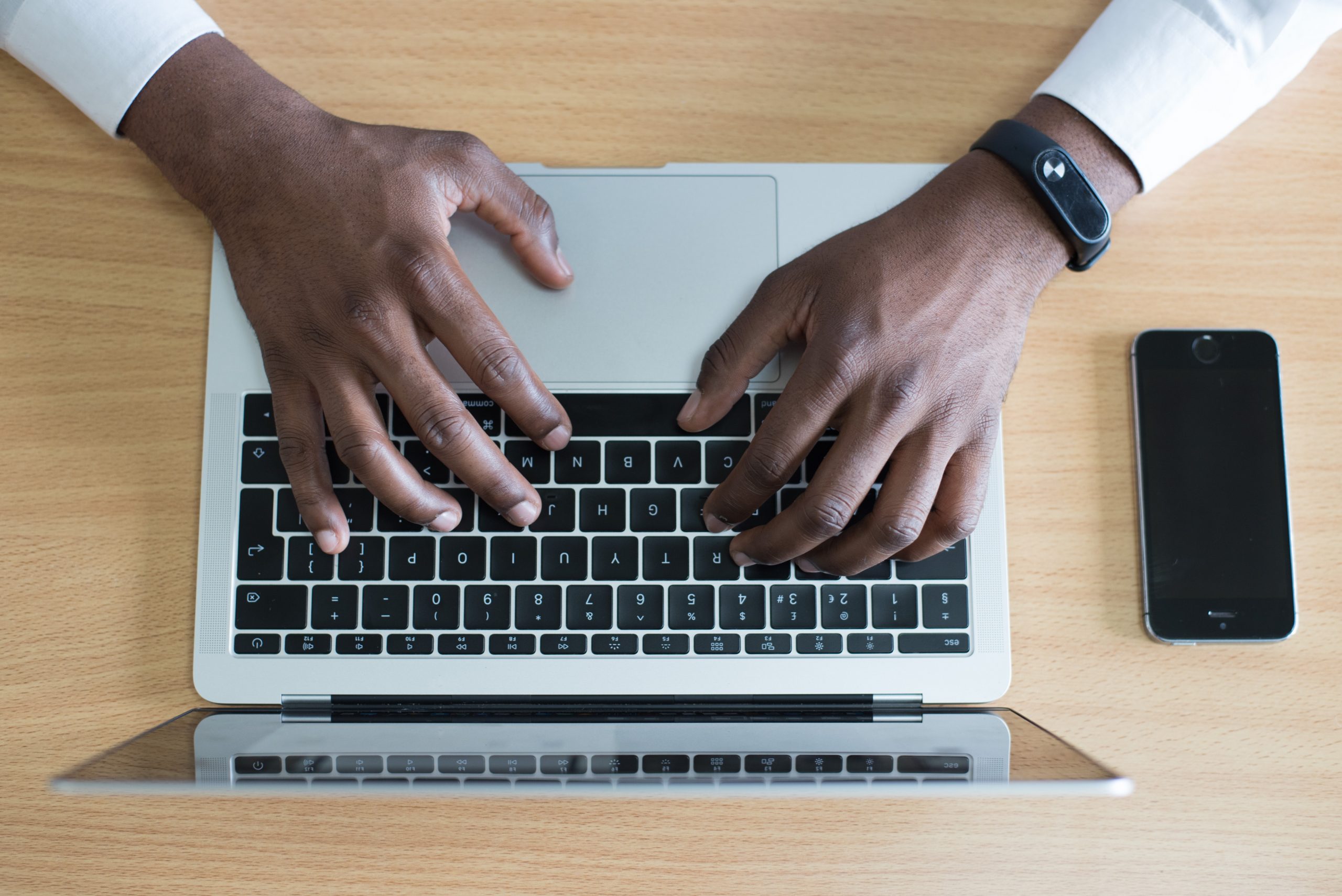 Black man types on a laptop