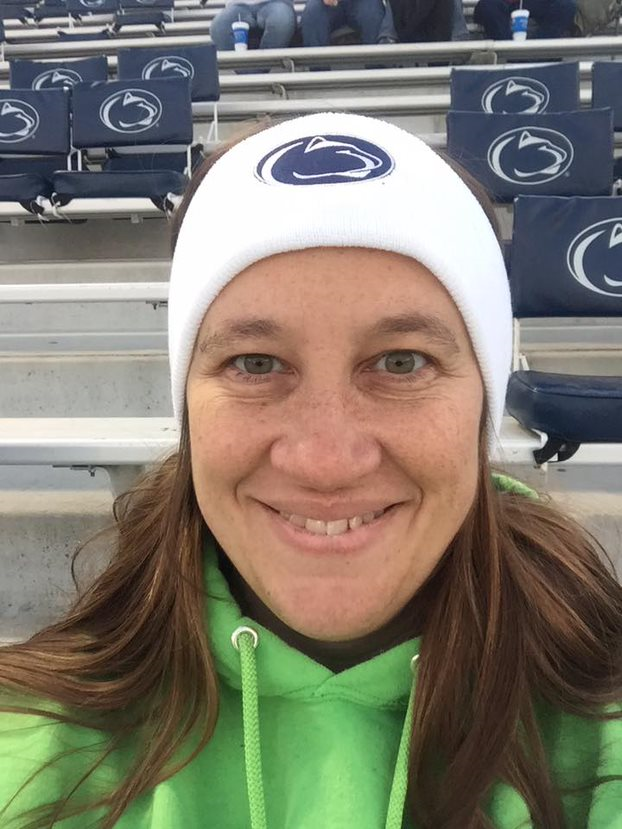 Woman with long brown hair wearing Penn State hat