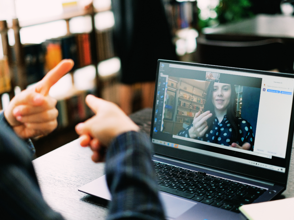 Person using sign language to communicate with someone else via a computer screen