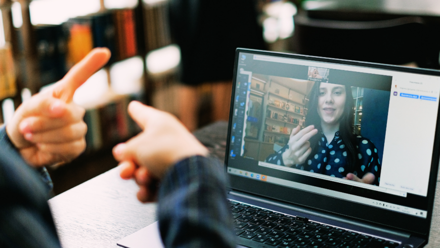 Person using sign language to communicate with someone else via a computer screen