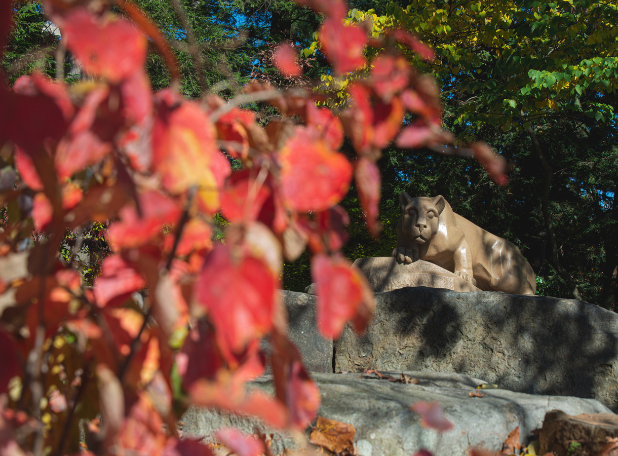 Lion shrine with red leaves and fall foliage in the foreground